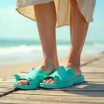 Femme portant des claquettes poisson turquoise originales sur une promenade en bord de mer en été