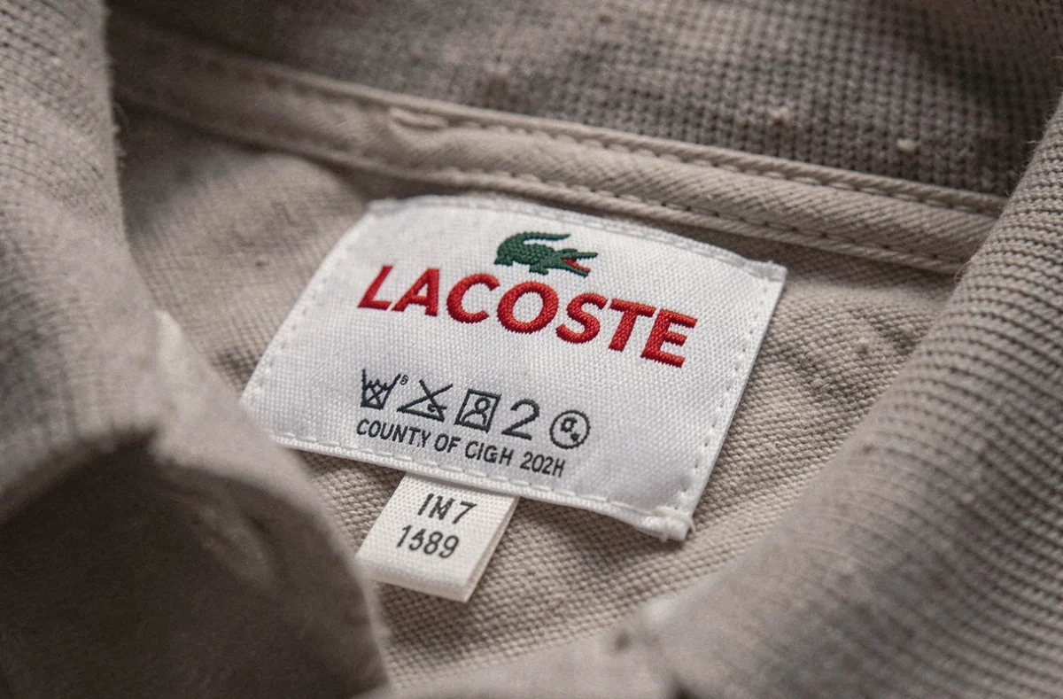 Étiquette intérieure d'un polo Lacoste authentique avec logo et inscriptions lisibles au col