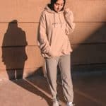 man in gray hoodie and pants standing on brown concrete floor