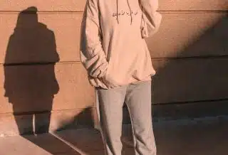 man in gray hoodie and pants standing on brown concrete floor